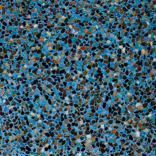 Close-up of a blue polished aggregate pool finish showing multicolored pebble texture